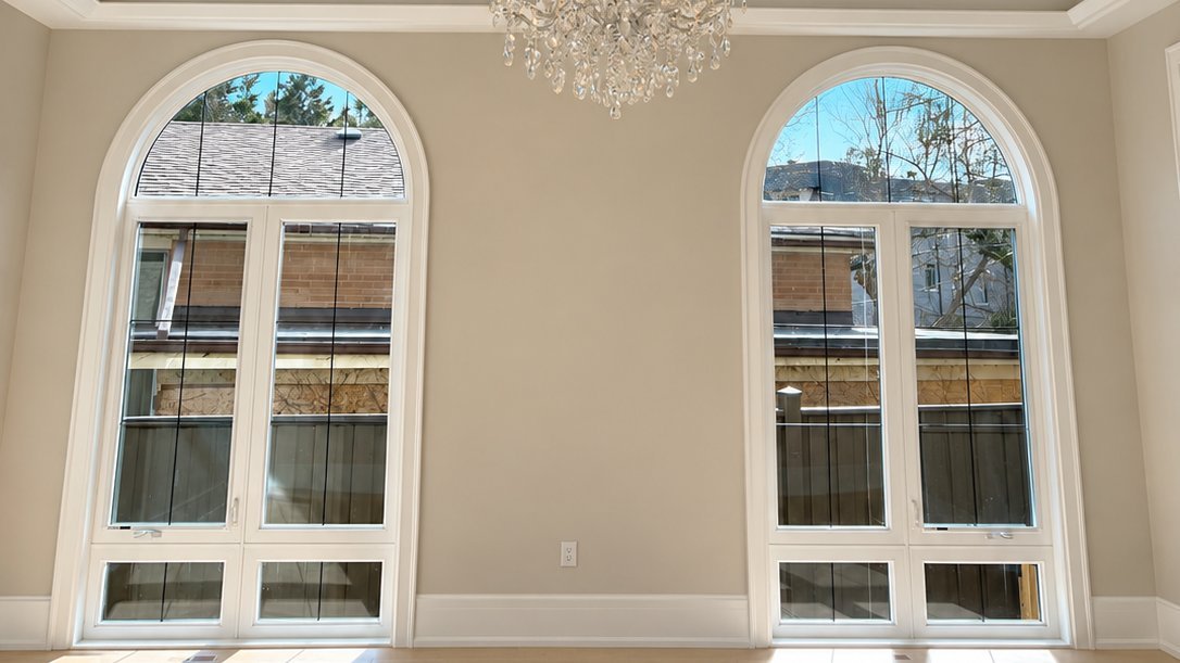 Arched windows with white painted trim and natural light in a freshly painted room