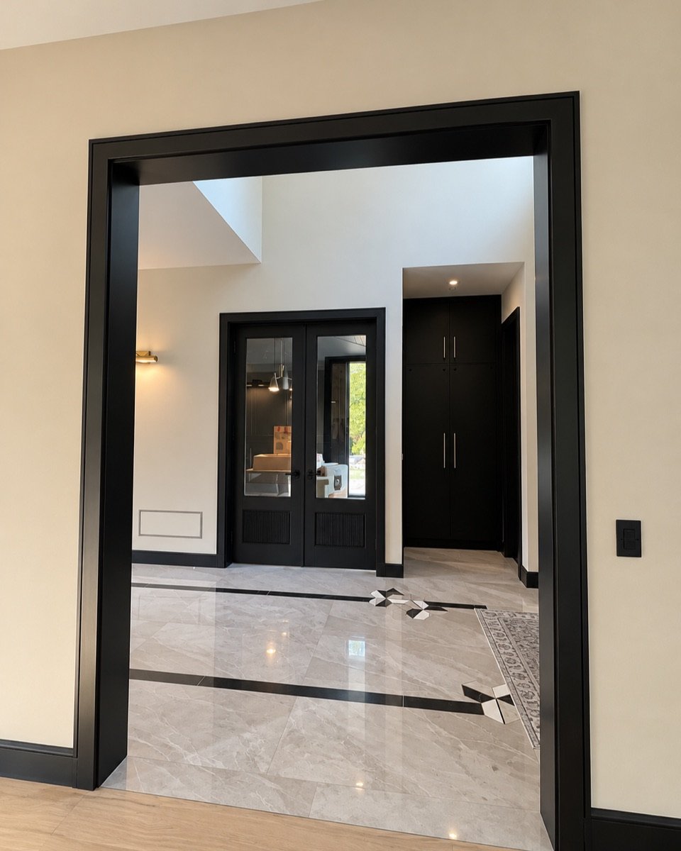 Black painted door casing and trim opening into an entry hall