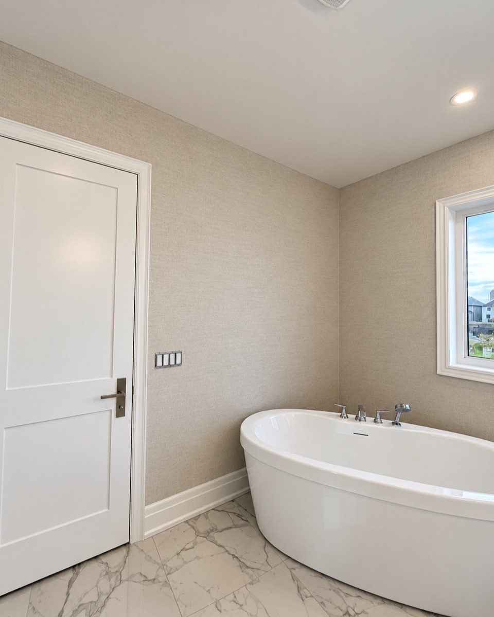 Textured grasscloth wallpaper and white trim in a master bathroom