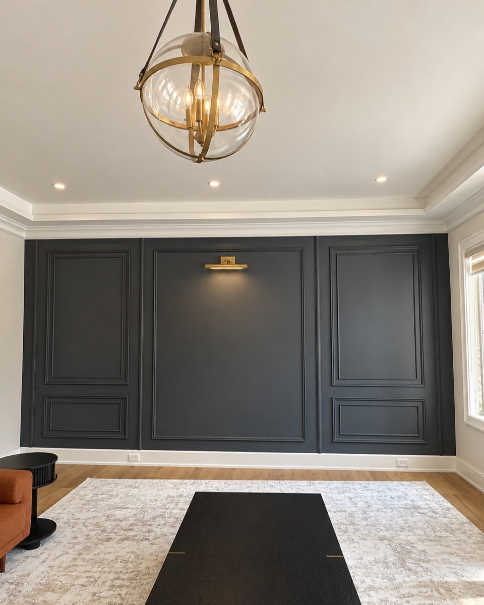 Dark charcoal painted wall with panel moulding in a Toronto living room