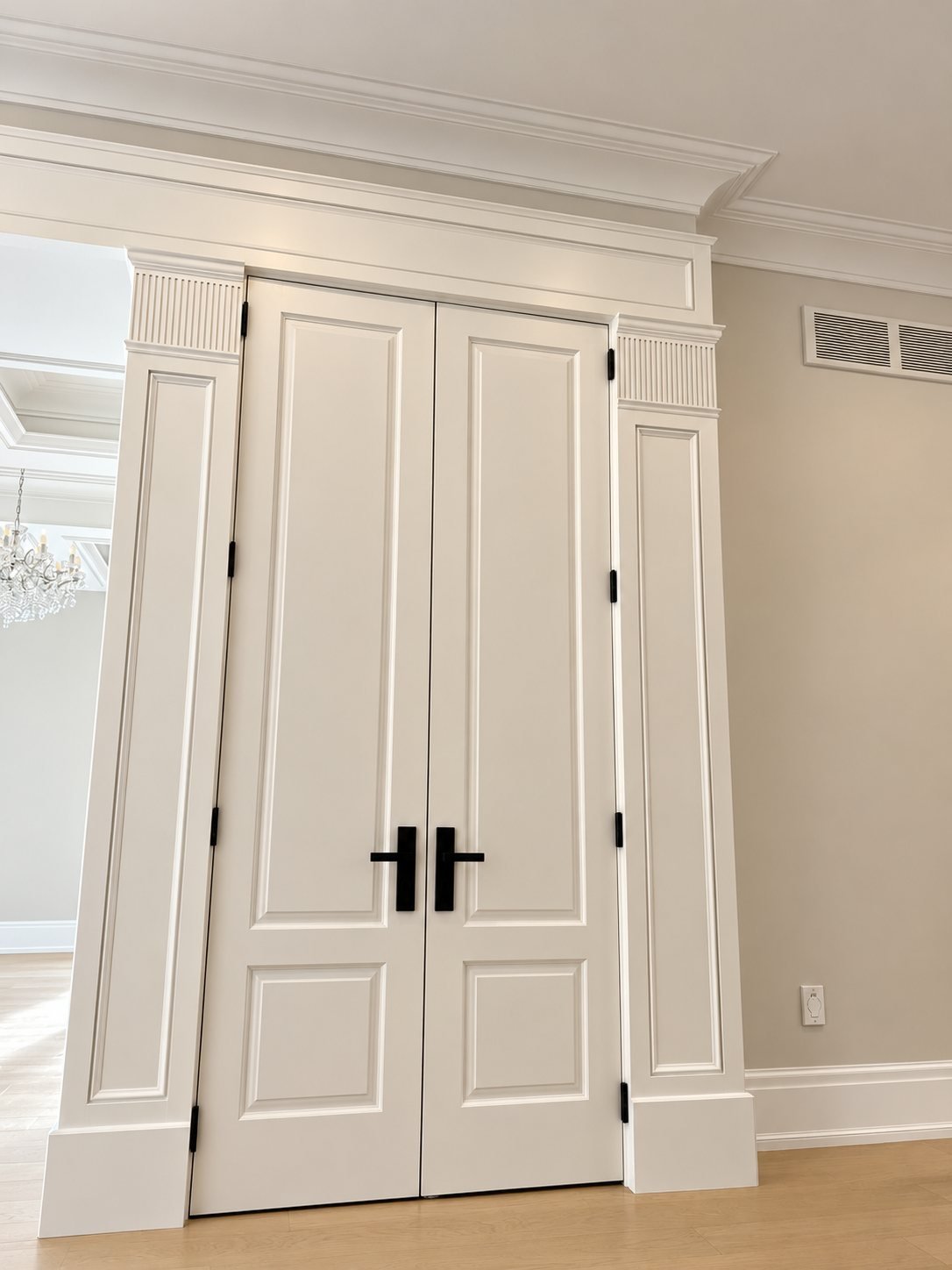 White painted double doors with classic casing and crown moulding