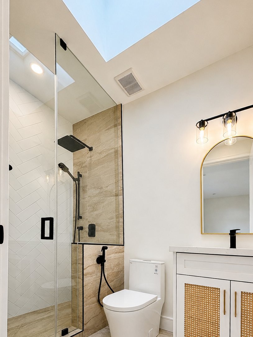 Bathroom with a skylight, freshly painted walls and a rattan vanity