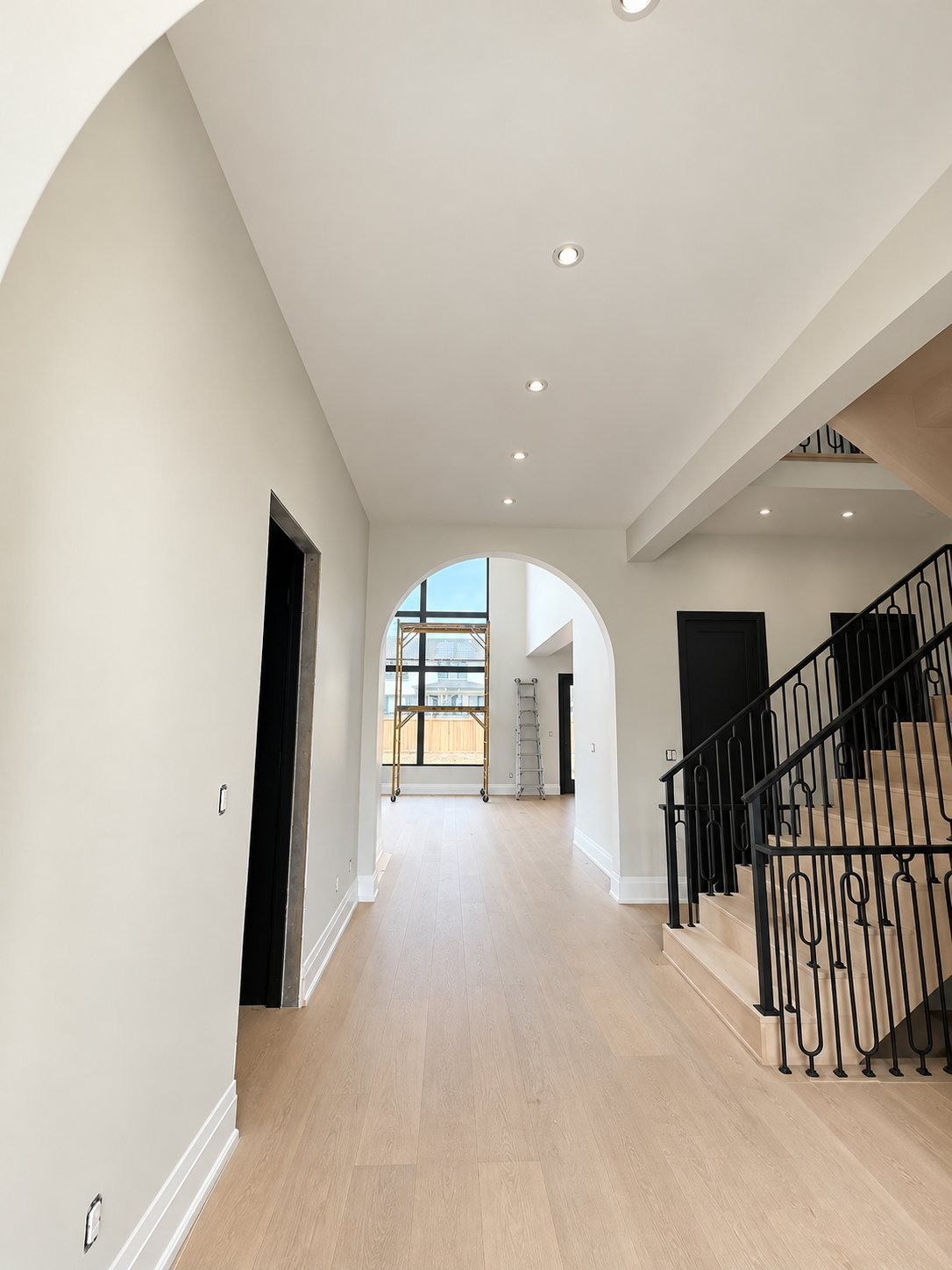 Arched hallway and staircase during the final stage of interior painting