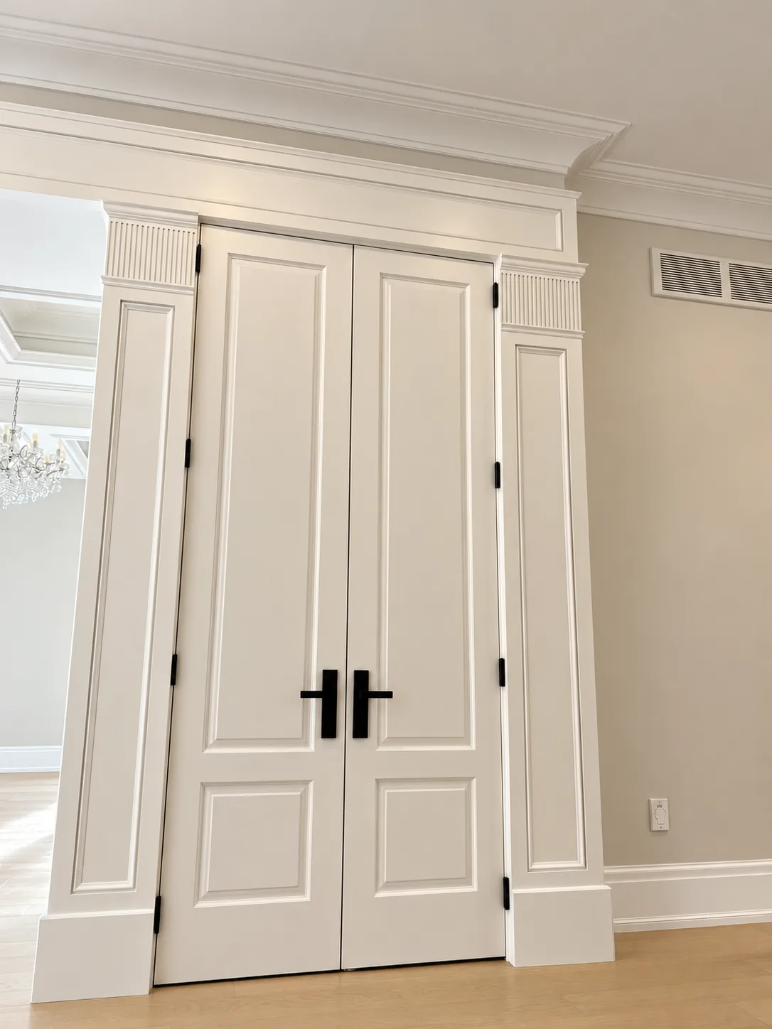 White painted double doors with classic casing and crown moulding