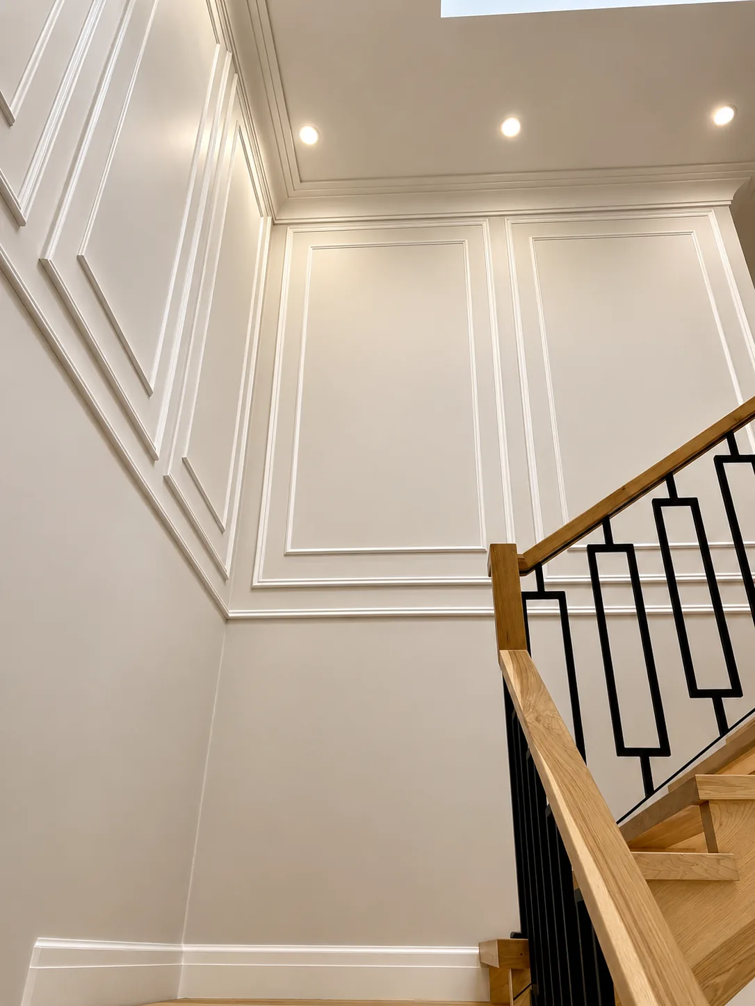 Stairwell wall with white painted panel moulding