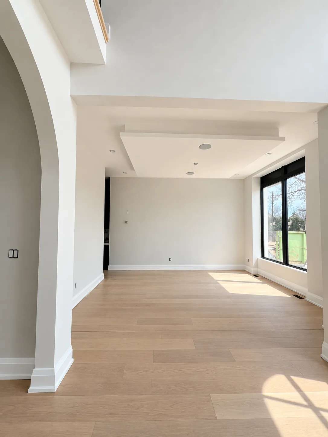 Empty living room with freshly painted walls, an arched opening and a dropped ceiling