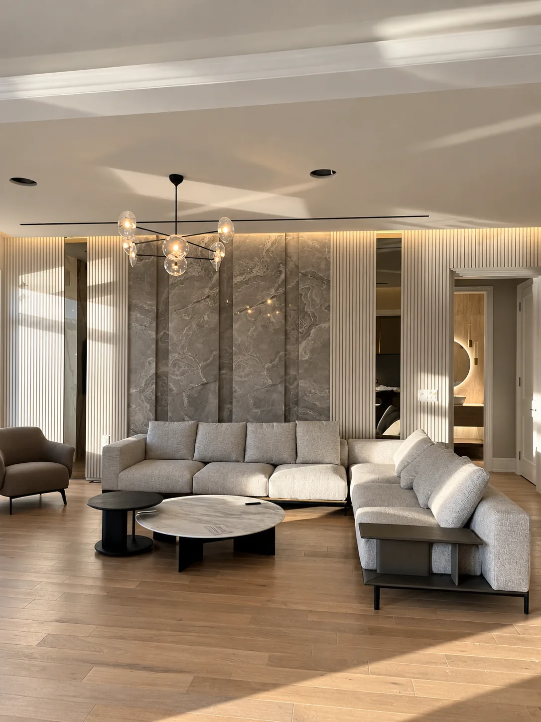 Furnished living room with fluted wall panels and a marble feature wall