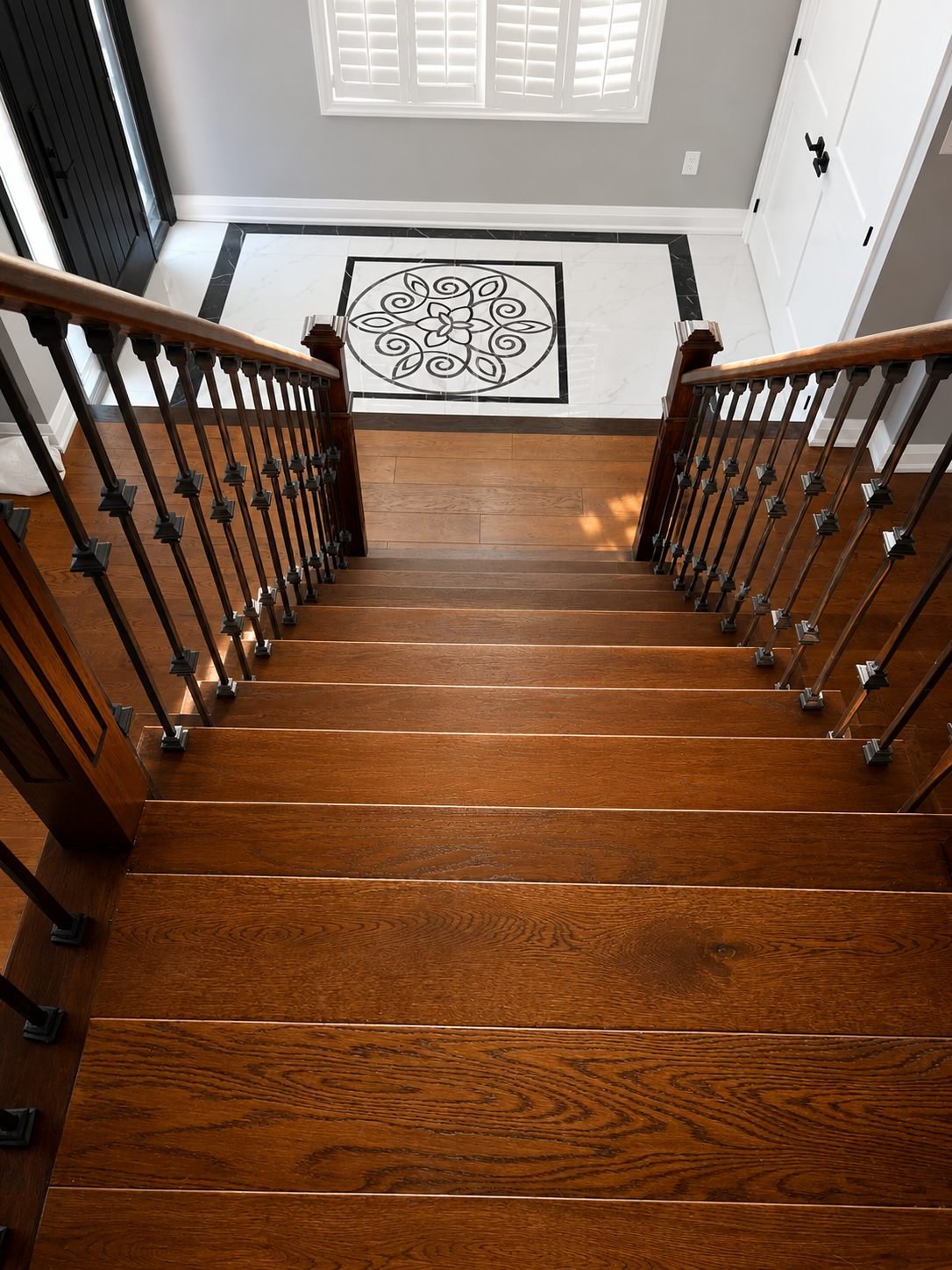 Stained and varnished wood stair treads with a rich grain, seen from the top landing