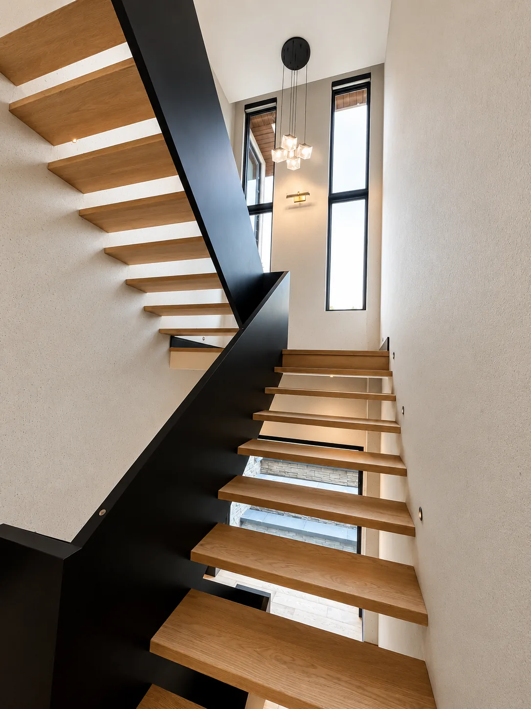 Floating staircase with stained oak treads and a black painted stringer