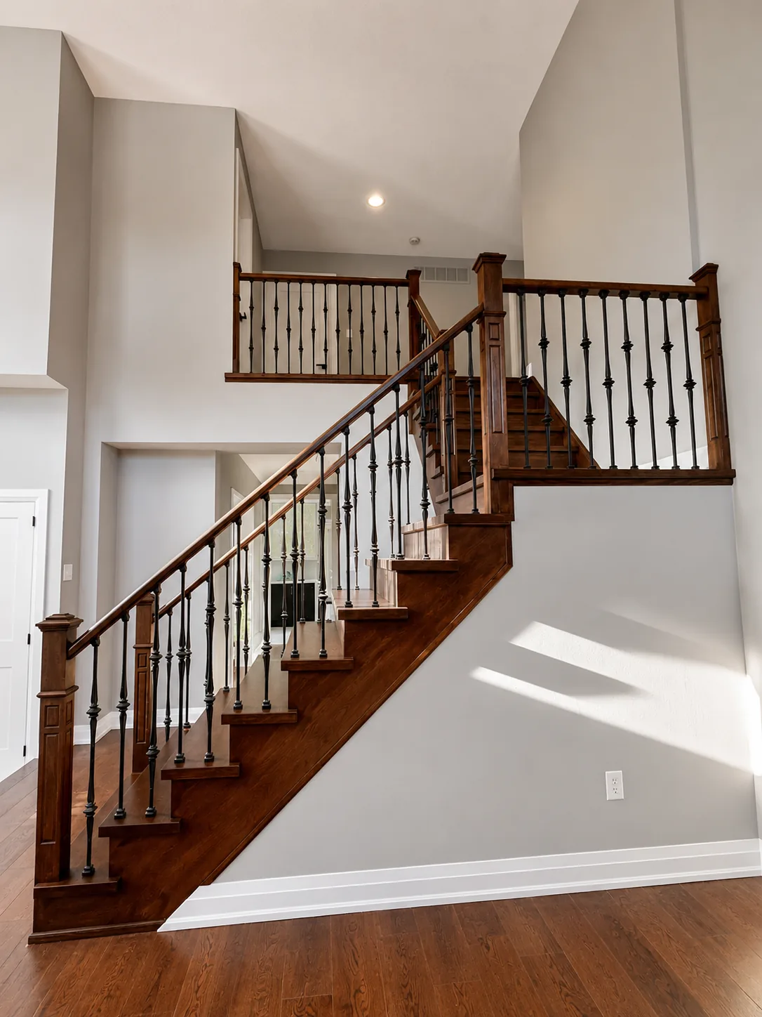 Cherry-stained wood staircase with wrought iron balusters