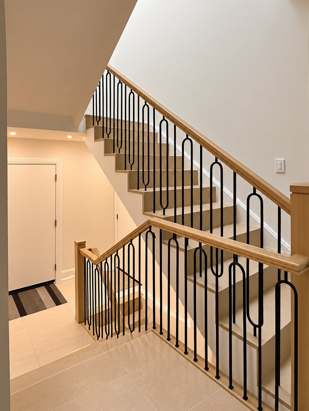 Staircase with a stained oak handrail and black balusters