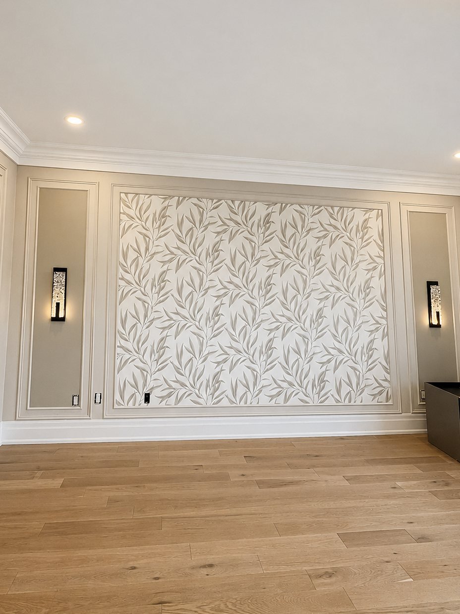 Botanical leaf wallpaper framed in painted wall moulding with black sconces