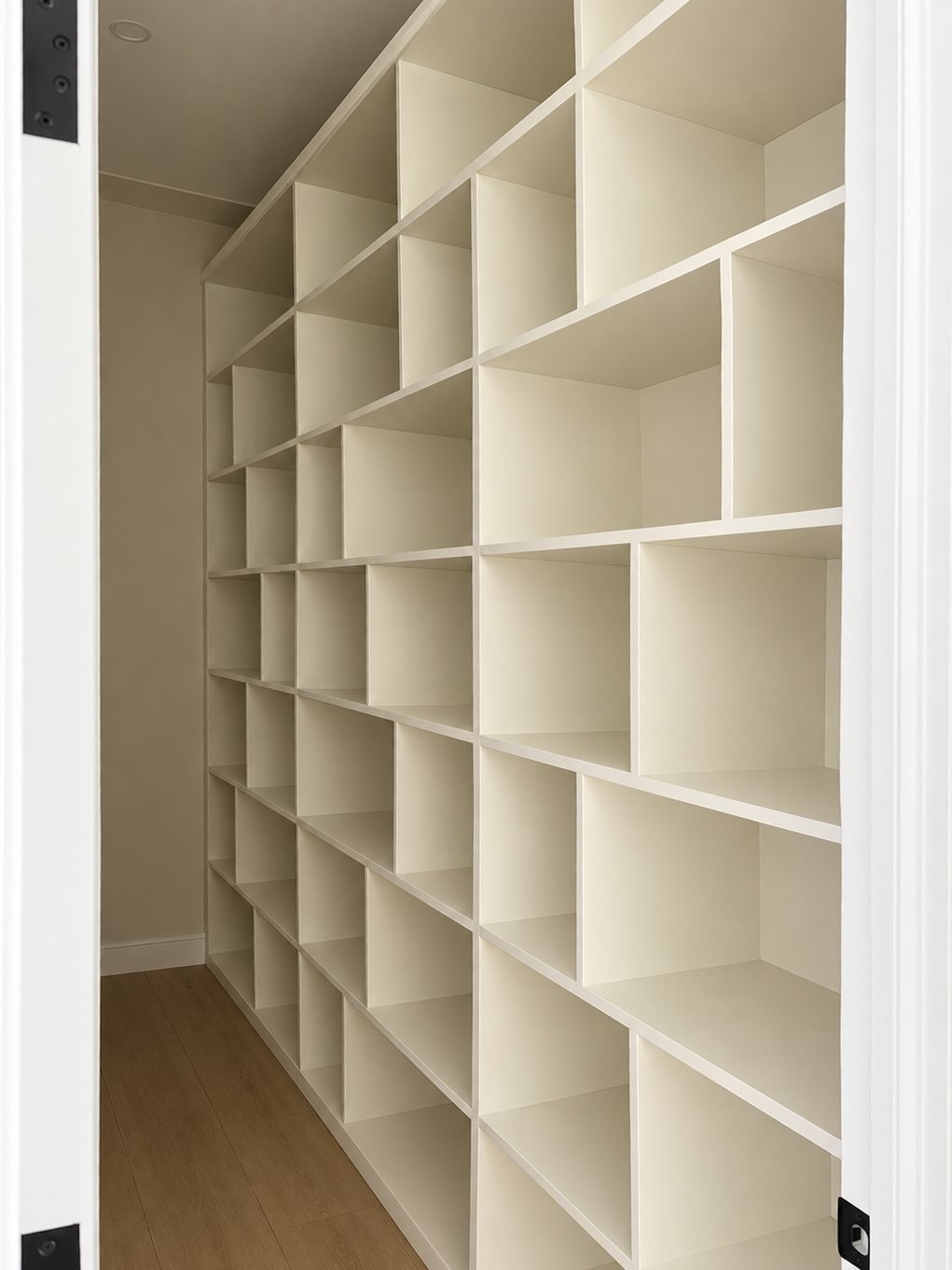 Spray-finished white built-in cubby shelving in a closet
