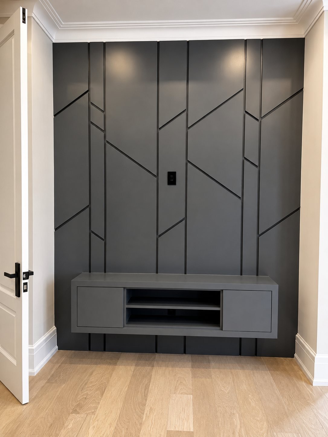 Spray-finished charcoal geometric wood wall panel with a floating media console